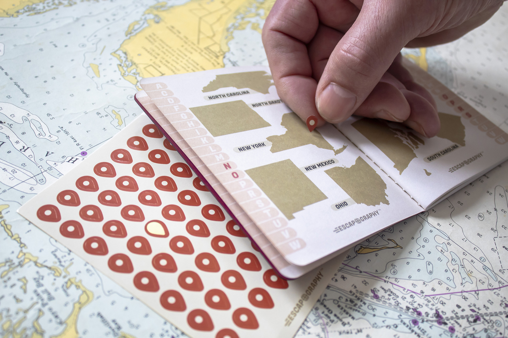 A photograph of the Escapography passport against a map.